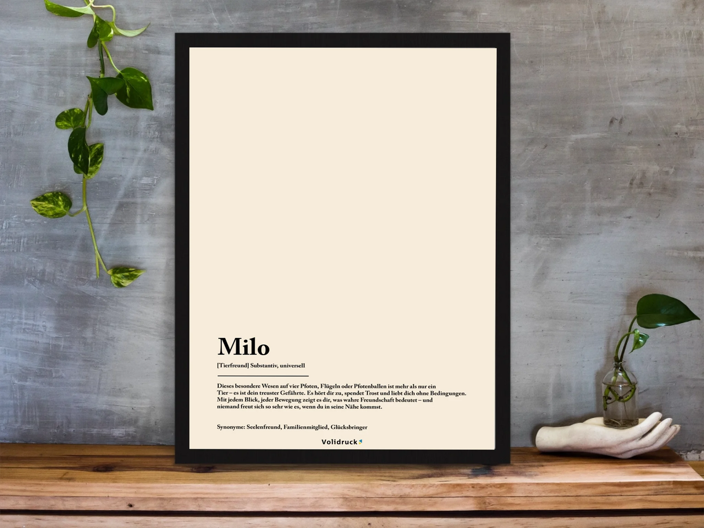 framed-art-print-standing-on-a-wooden-desk-against-a-concrete-wall-near-a-hand-decoration-a10403-2