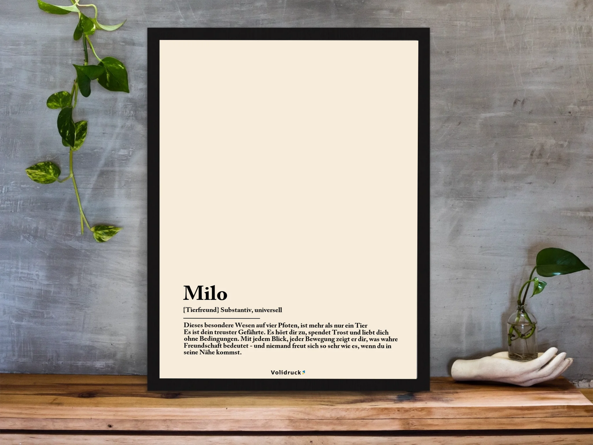framed-art-print-standing-on-a-wooden-desk-against-a-concrete-wall-near-a-hand-decoration-a10403-2